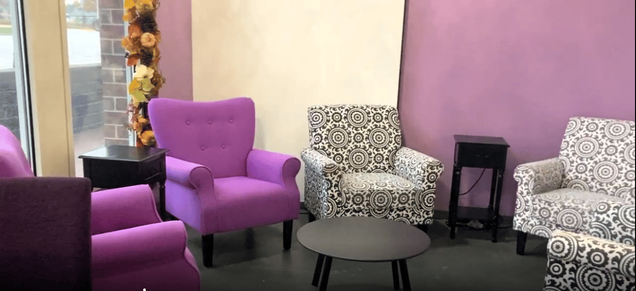 A sitting area with several pieces of furniture, including armchairs and side tables, arranged in a semi-circular layout. In the center is a round coffee table.