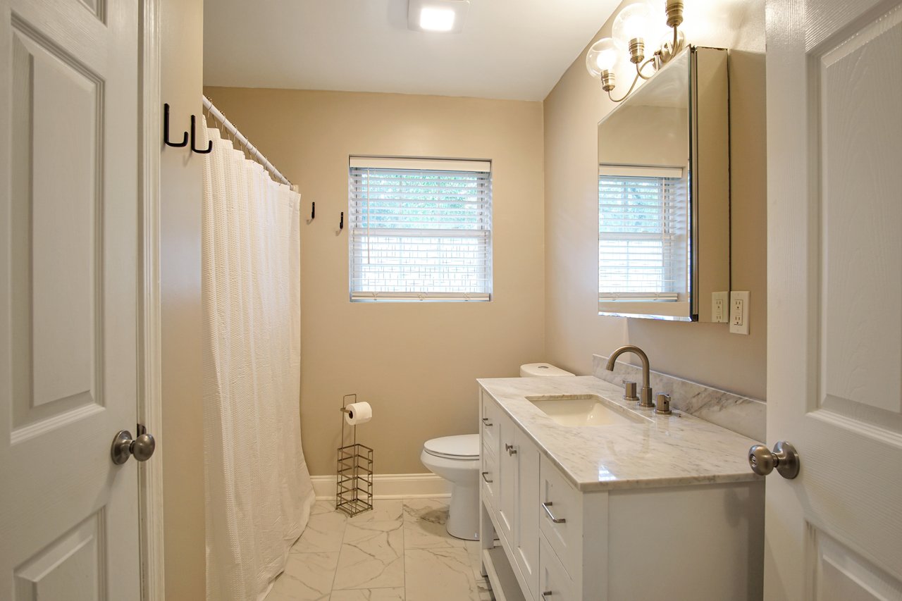 A bathroom featuring a window and a toilet, showcasing a clean and functional design.