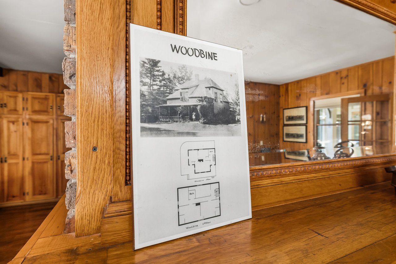 Woodbine display board with a historic house photo and two floor plans on a wooden counter.