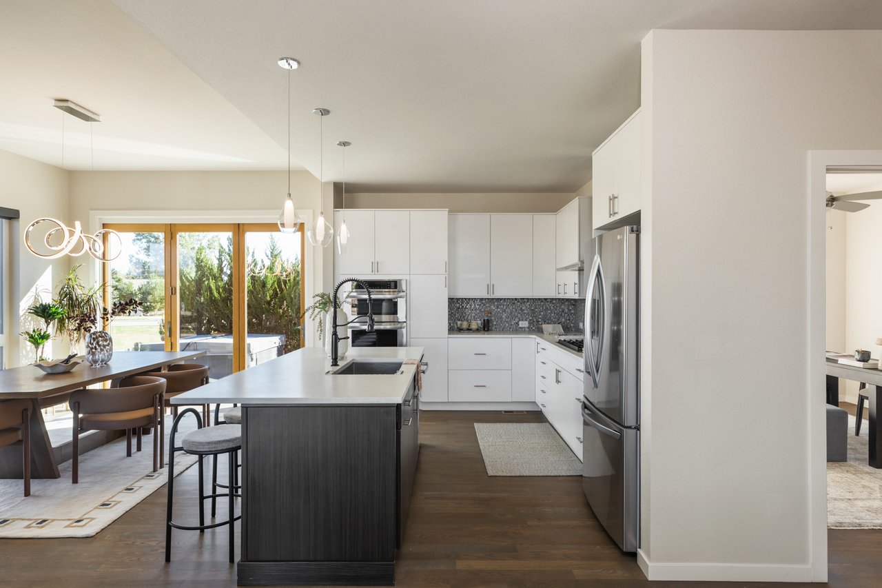 Kitchen island and dining area with open accordion doors to the patio beyond