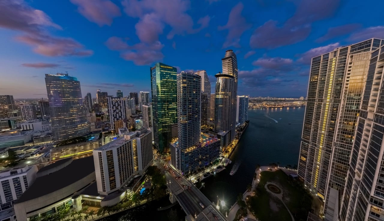 Aerial view of Brickell’s waterfront skyline at dusk, with high-rises beside the bay.