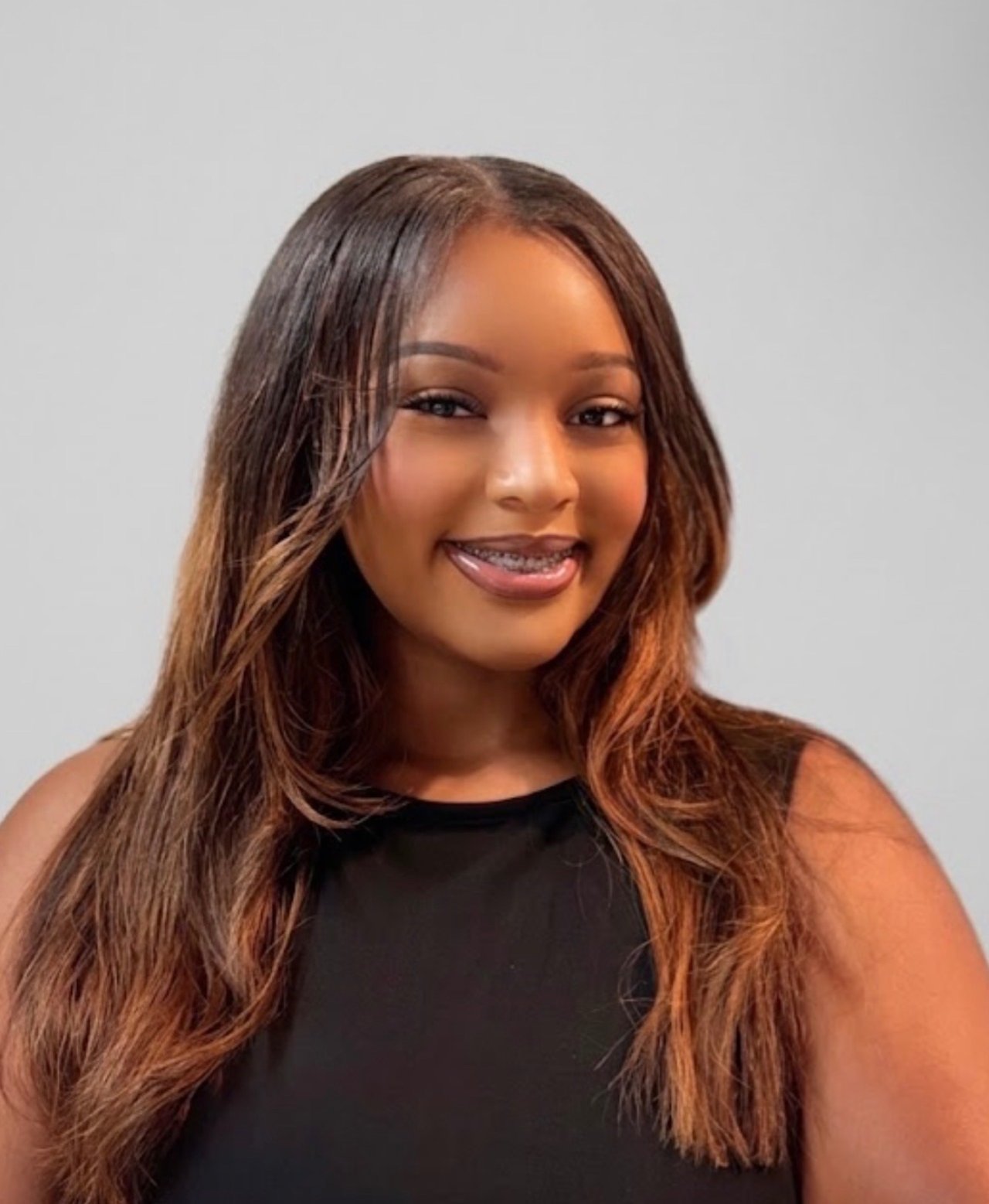 Angelene Lamar, smiling in a black sleeveless top against a plain light background.