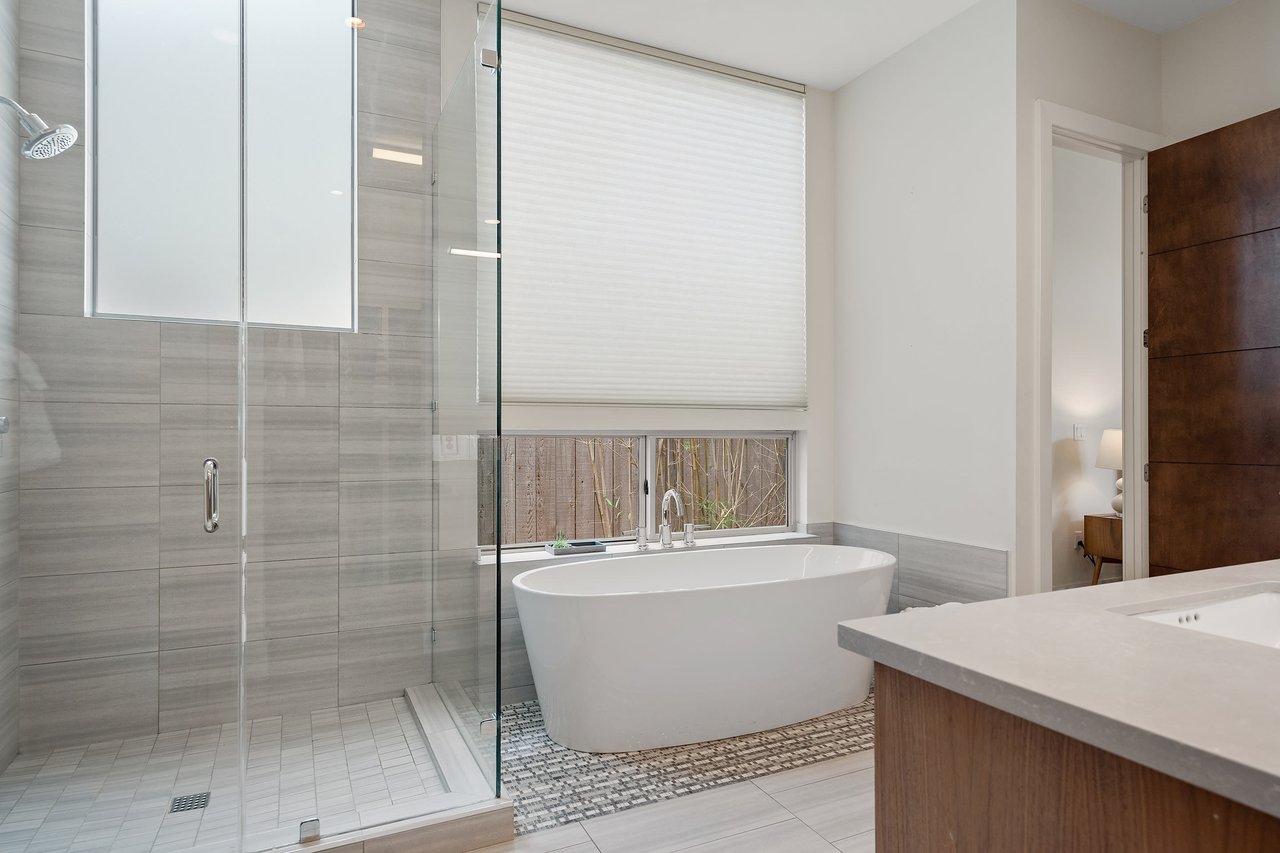Primary bathroom with a freestanding tub, glass shower, and tile finishes at 34 Margranita Crescent, Tarrytown, Austin, TX.