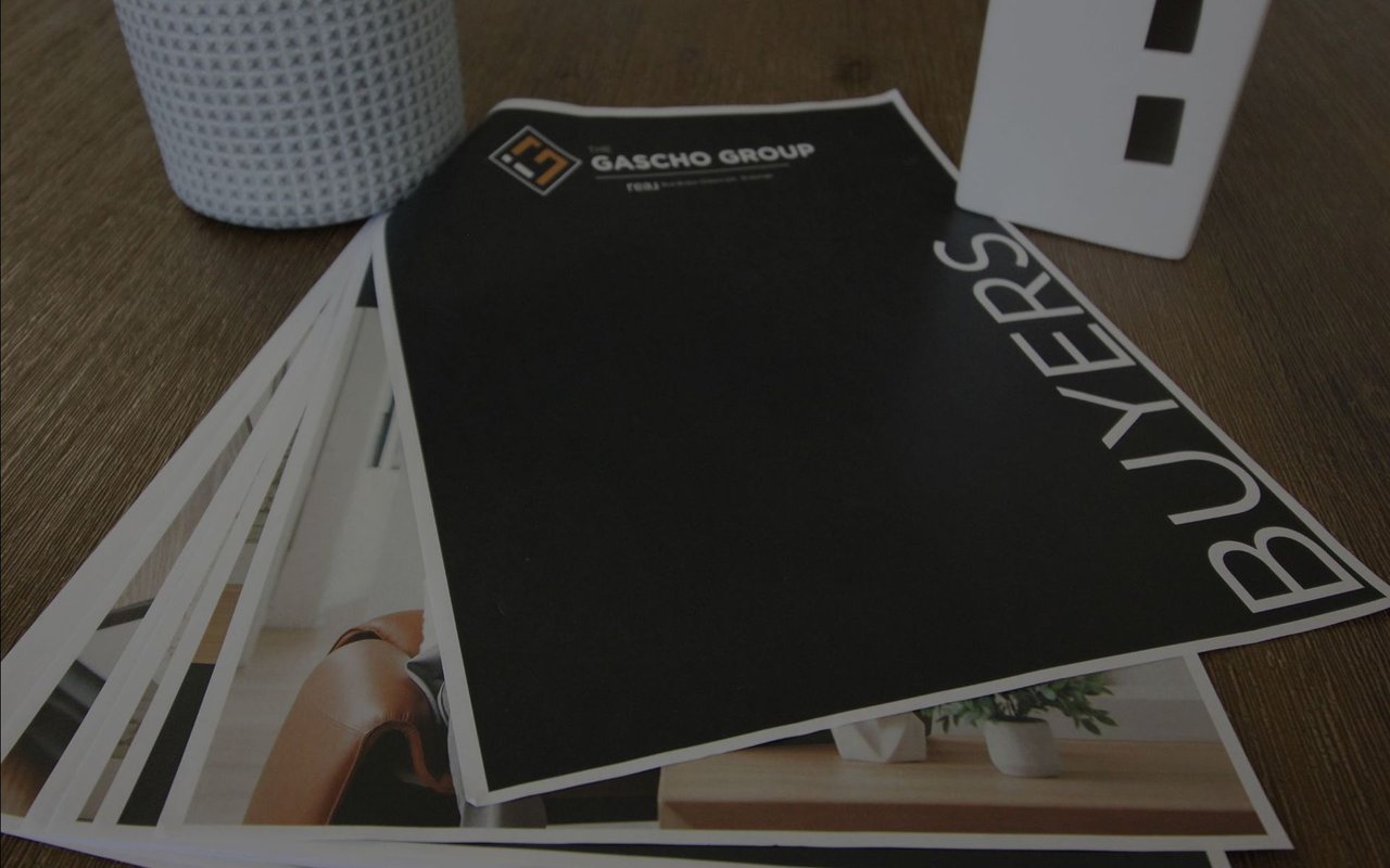 Gascho Group buyer guide cover labeled “BUYERS” on a stack of brochures.