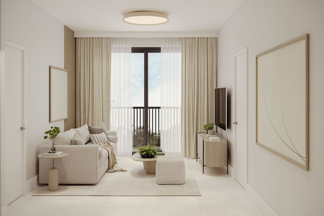 Staged living room with a neutral sofa, pale wood furnishings, and curtains framing a balcony door.
