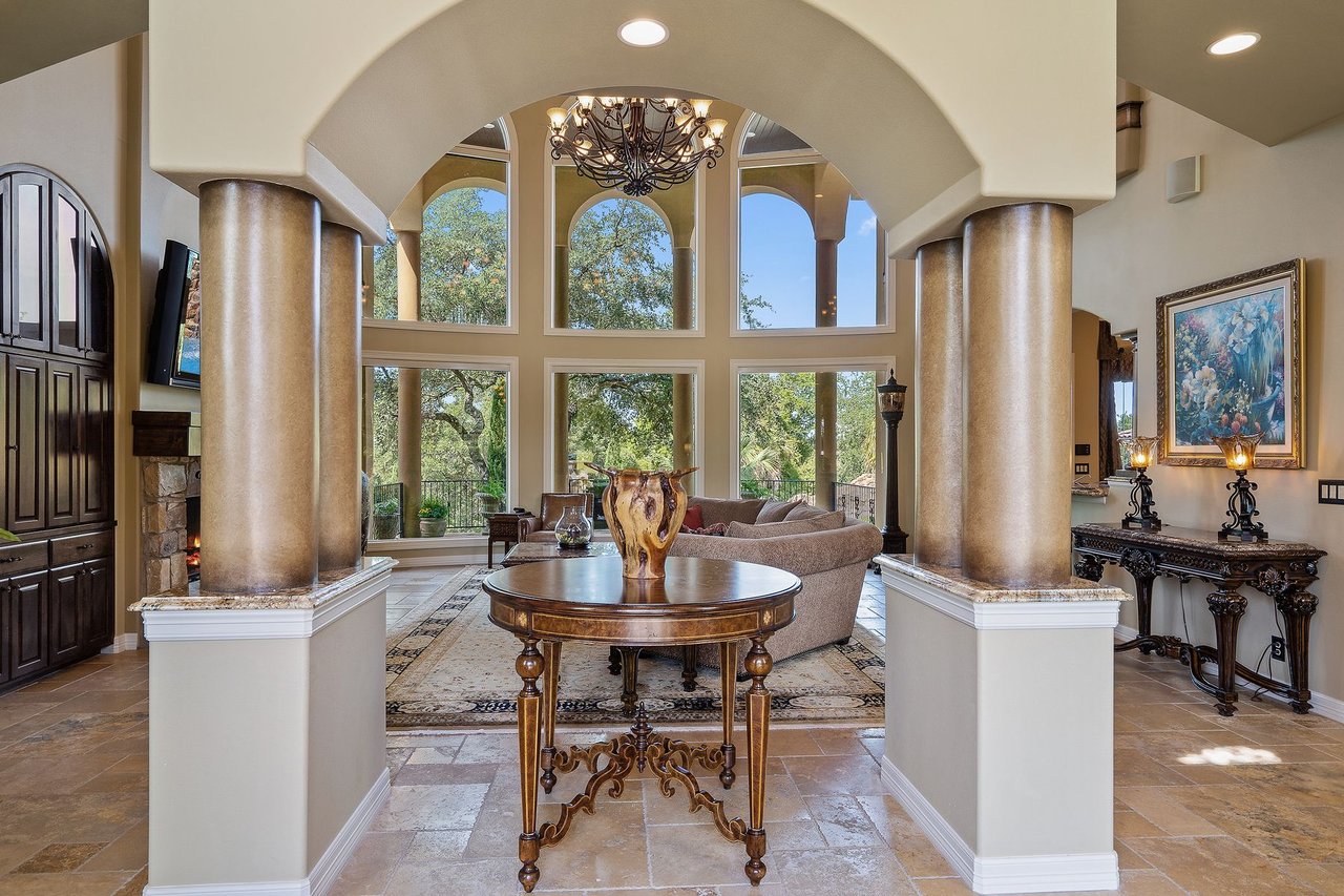 Entry rotunda with tall columns and a two-story window wall at 25715 Cliff Circle, Lakecliff on Lake Travis, Spicewood, Texas.