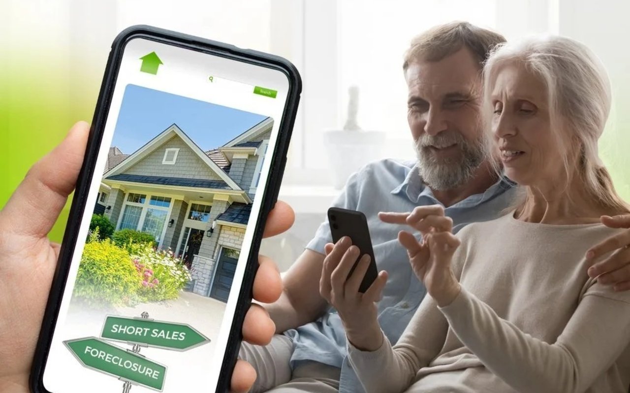 An older couple browses a home listing on a phone beside signs for short sales and foreclosure.
