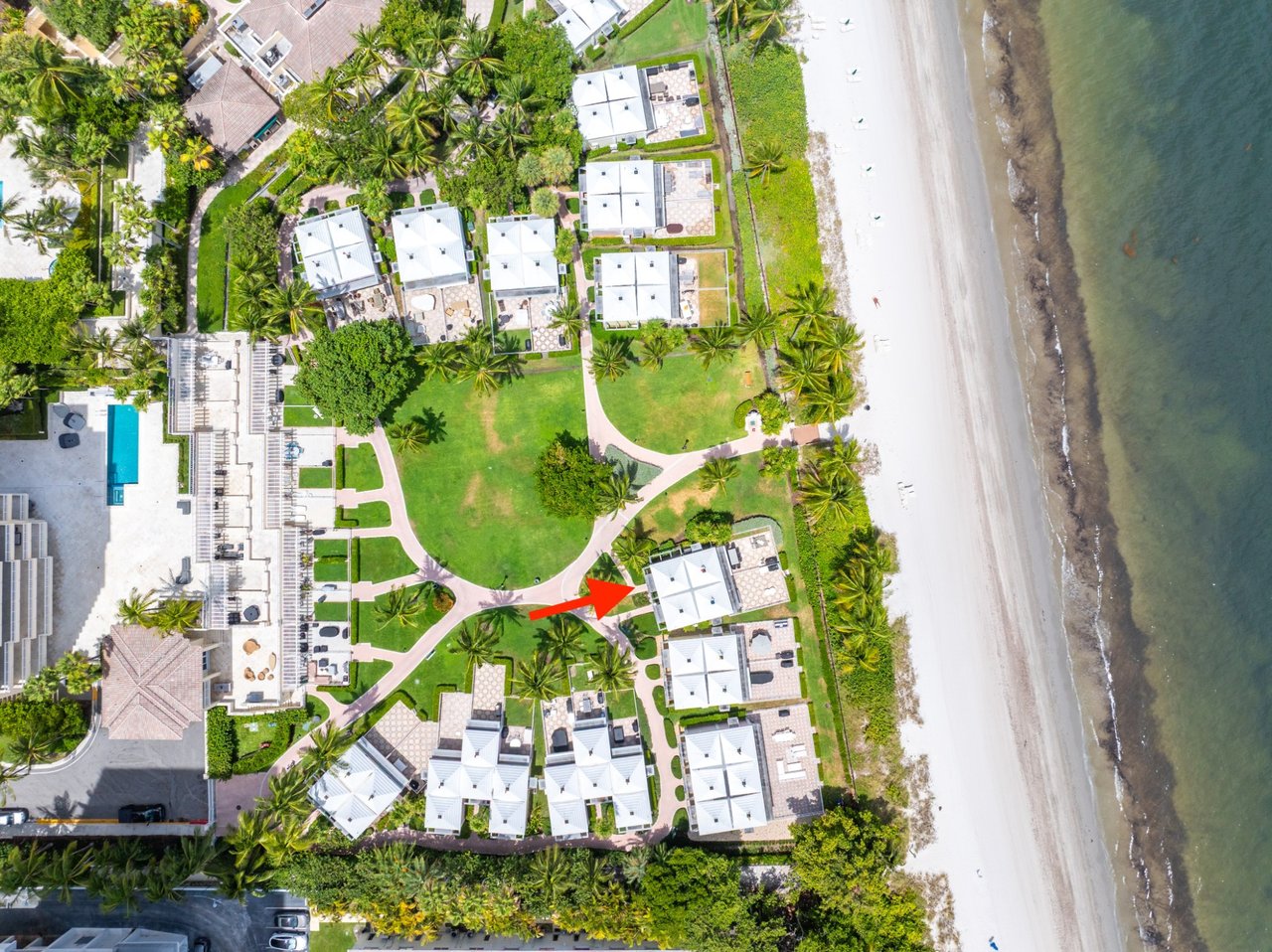 Aerial view of Cabana #101, marked by a red arrow among beachfront cabanas and palm-lined grounds.