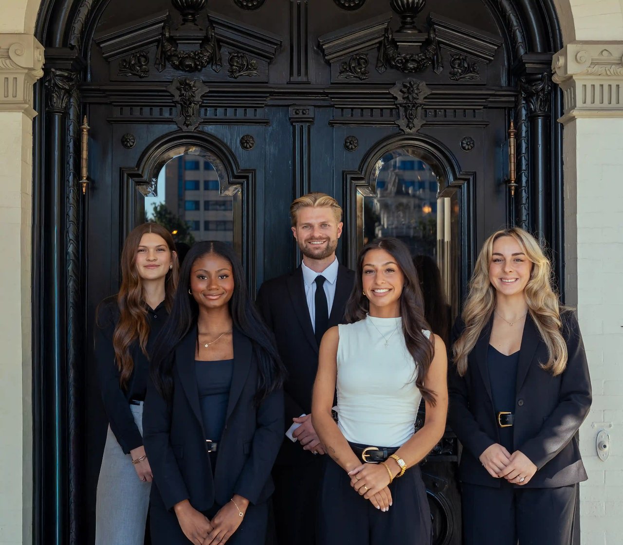 Luxe Haven Group real estate team standing together outside historic Milwaukee building.