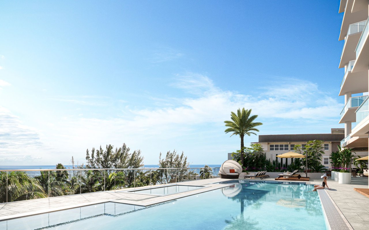 Swimming pool and sun deck at Salato Residences, with ocean views and palm trees.
