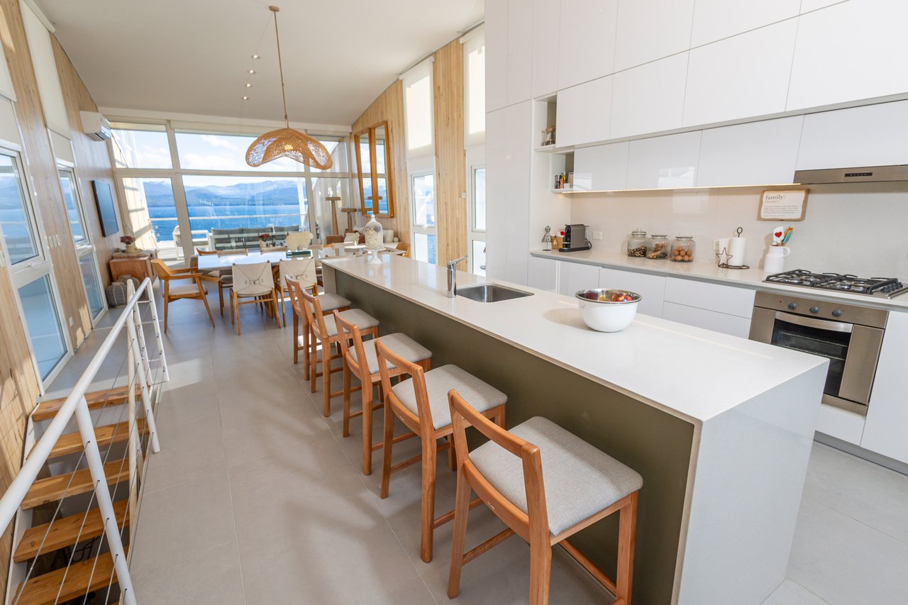 Open-plan kitchen and dining area with a long island and lake and mountain views.