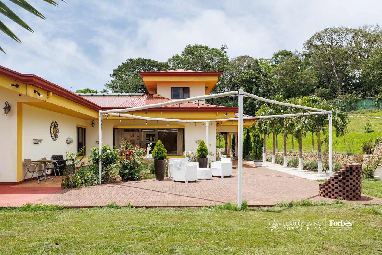House rear patio with red roofs, white seating, and a brick-paved courtyard.