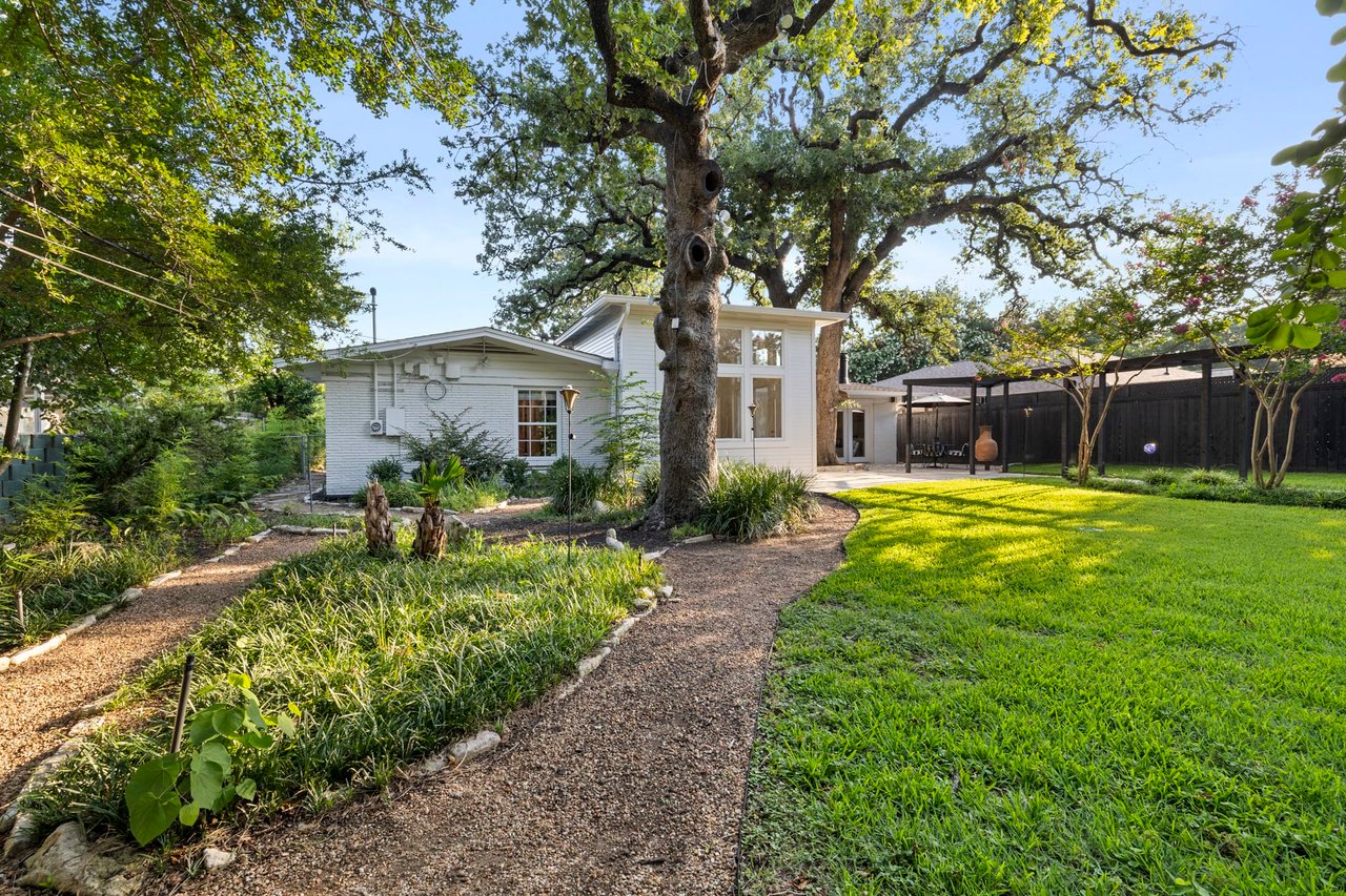 Side yard gravel walking path beneath mature oak trees, Tarrytown, Austin.