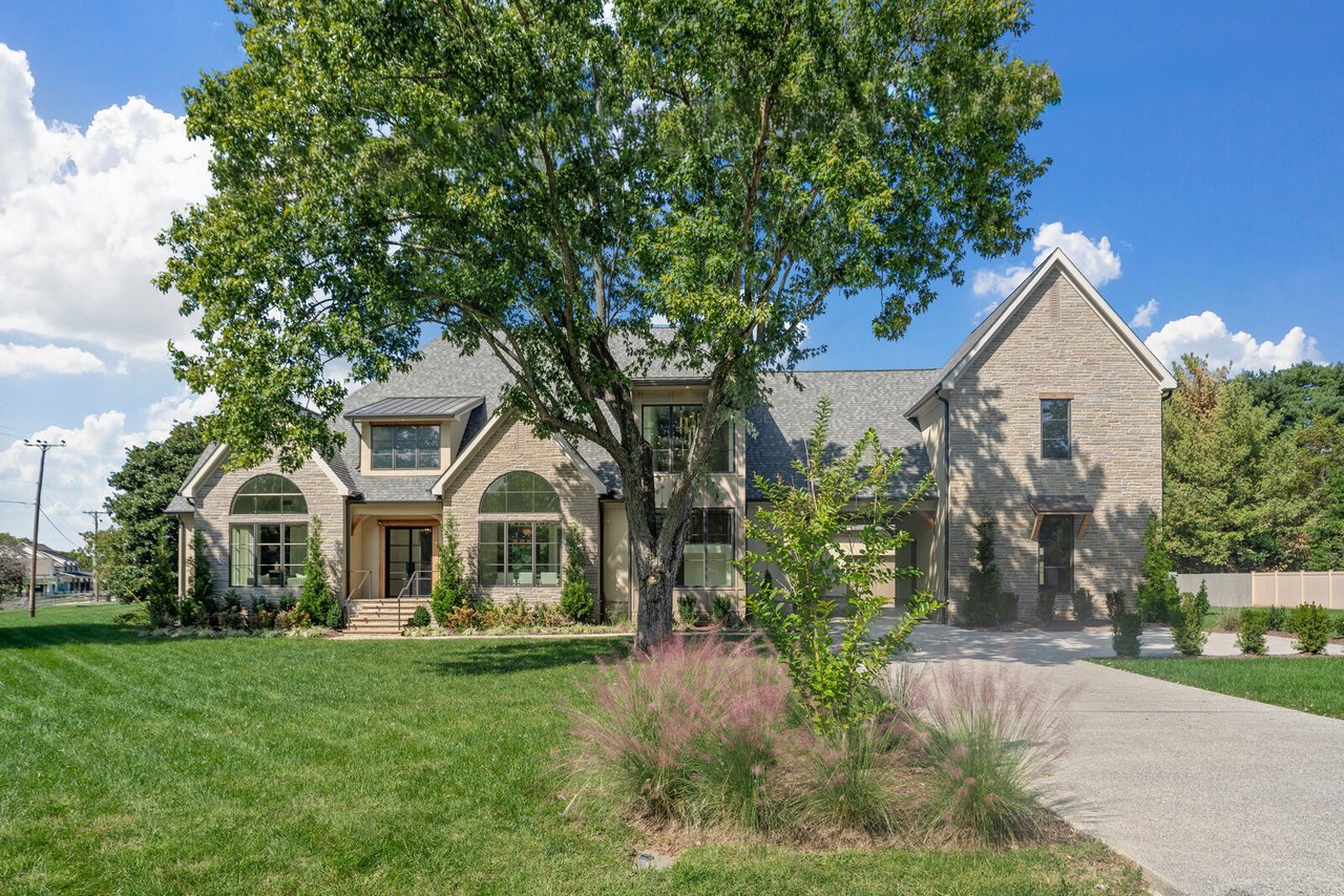 Wide view of 521 Mansion Dr, Brentwood — lawn, mature trees, stone exterior