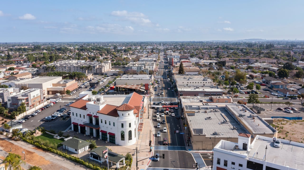 Aerial view of Bellflower’s commercial district, with a main street running through low-rise buildings.