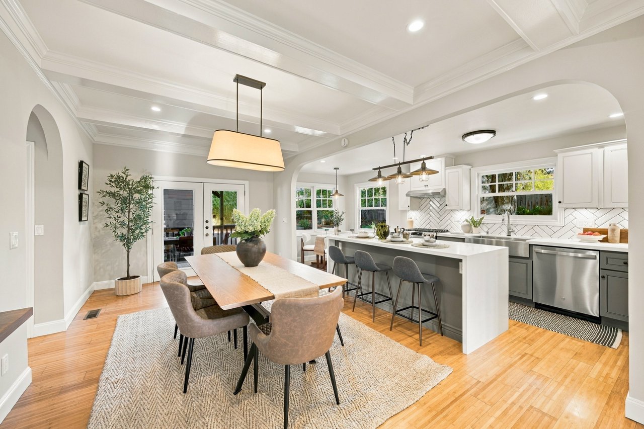 Open kitchen and dining area with a large island, gray cabinets, and coffered ceilings.