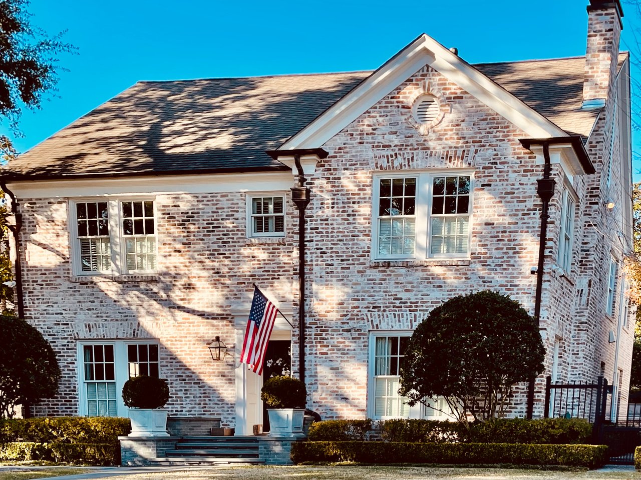 Two story Georgian style luxury home in Houston flying the American Flag