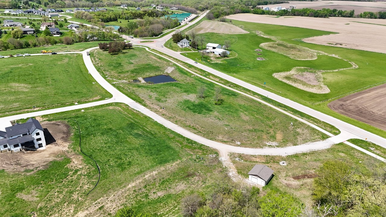 Aerial view of Oak Meadow’s grassy building lots, new roads, and scattered homes.