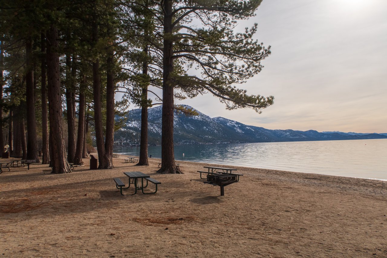 Sandy shoreline and clear blue water at a private IVGID beach in Incline Village, Nevada, on the north shore of Lake Tahoe.