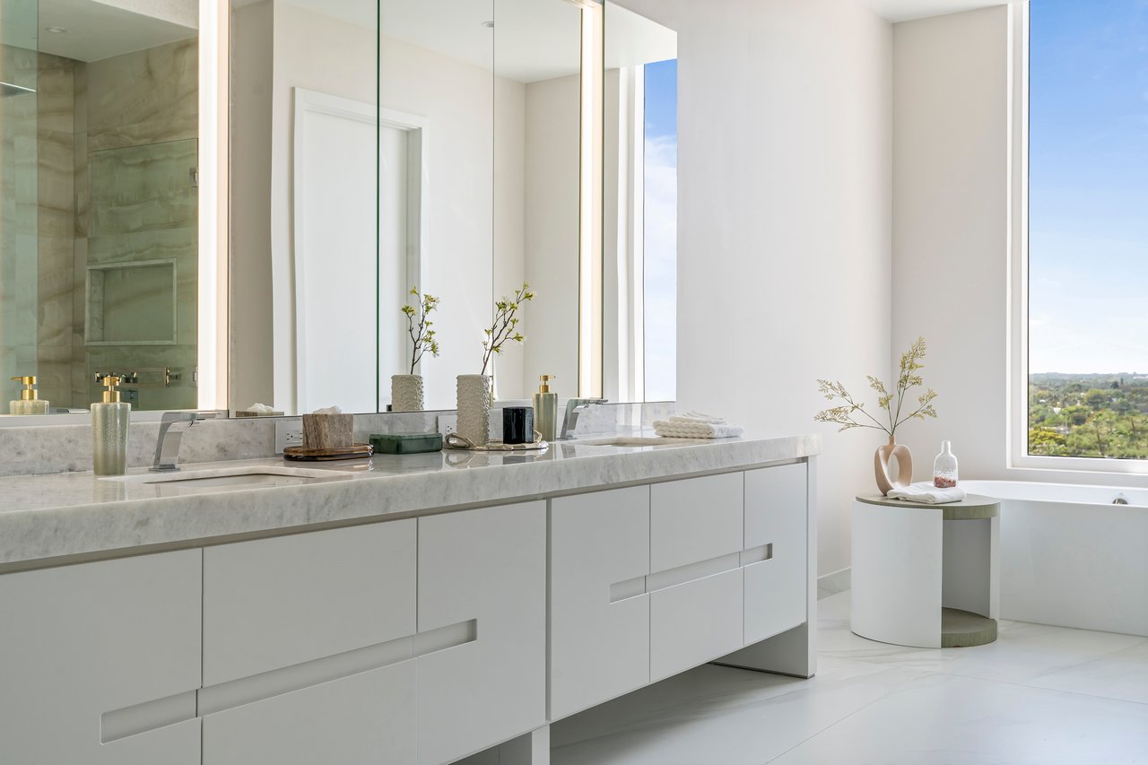 ALINA Residences bathroom in Boca Raton with a long double vanity, mirrors and freestanding tub.