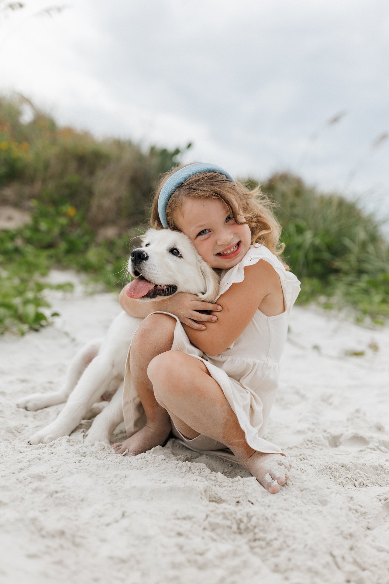 child holding puppy dog on beach