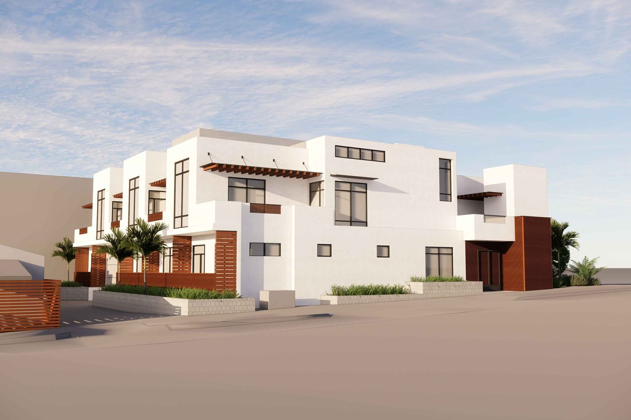 Modern white multi-story beach house with wood accents and palms, viewed from the street.