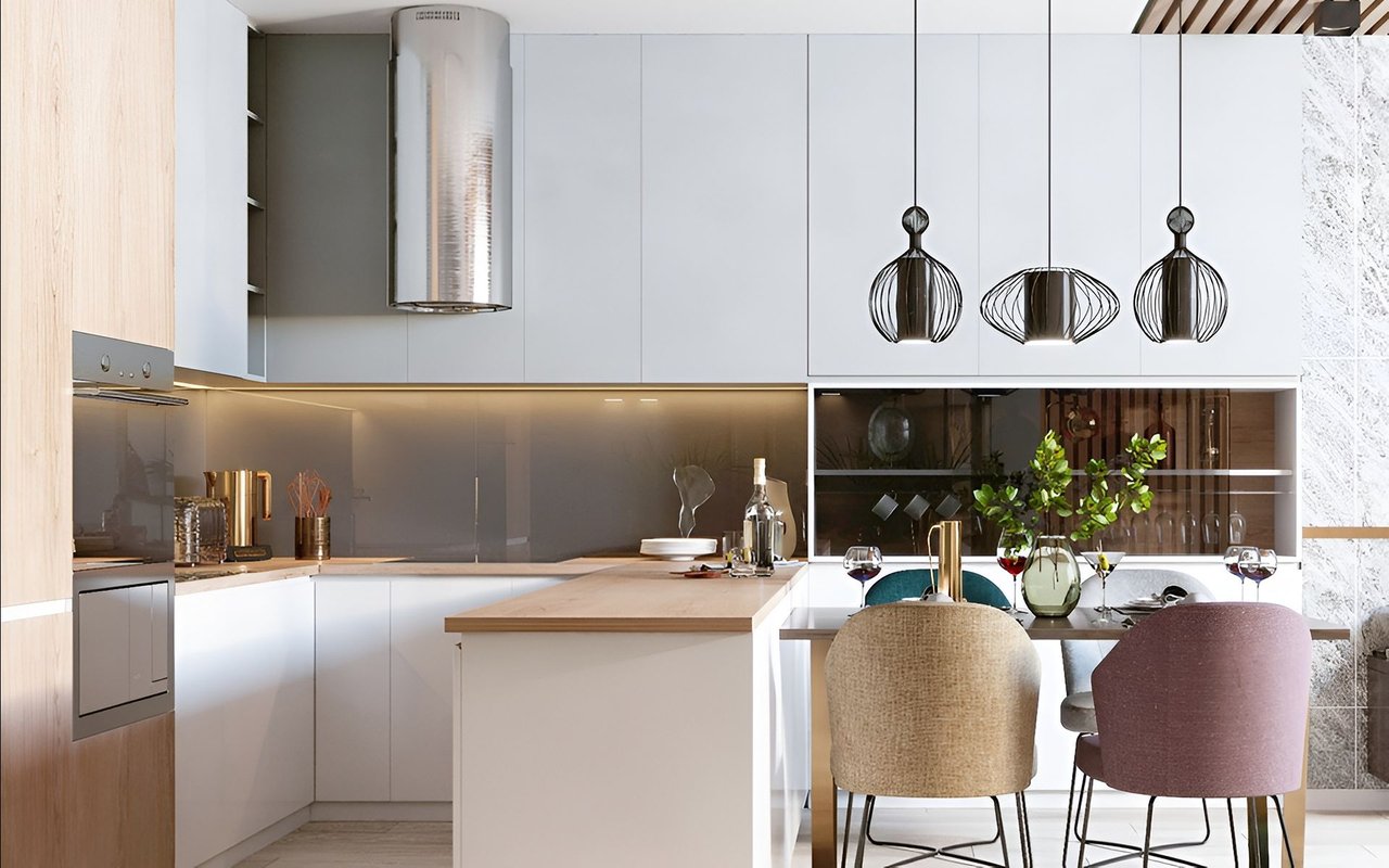 Modern white kitchen with a wood-accented island and three sculptural pendant lights.