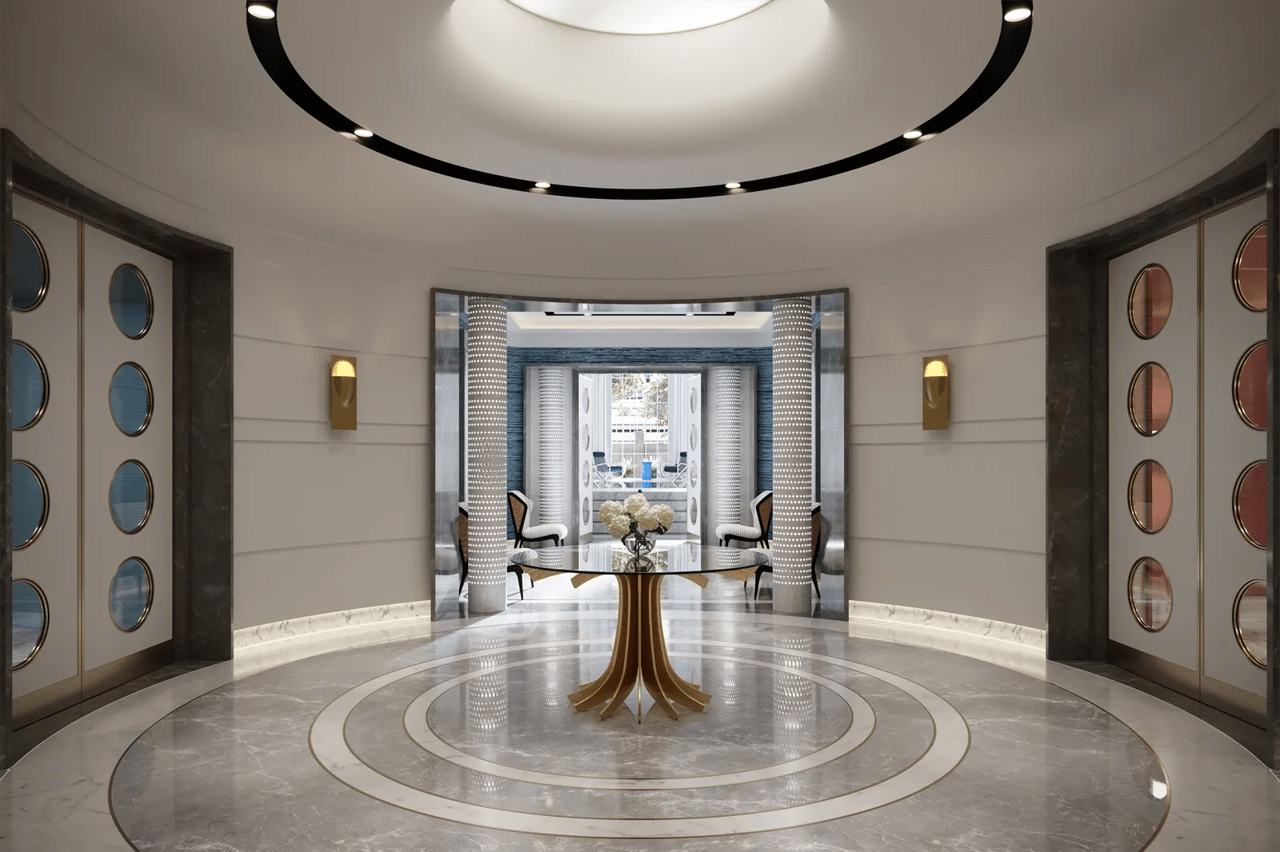 Residential lobby with a round marble floor, central table, and patterned columns.
