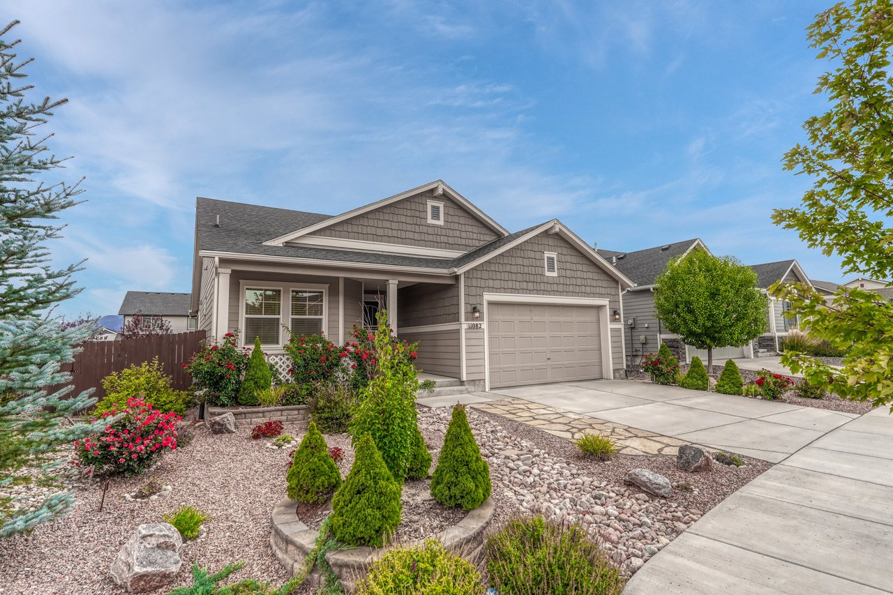 Front of 11082 Falling Snow Lane, Colorado Springs, with terraced xeriscape beds, roses and a flagstone walkway