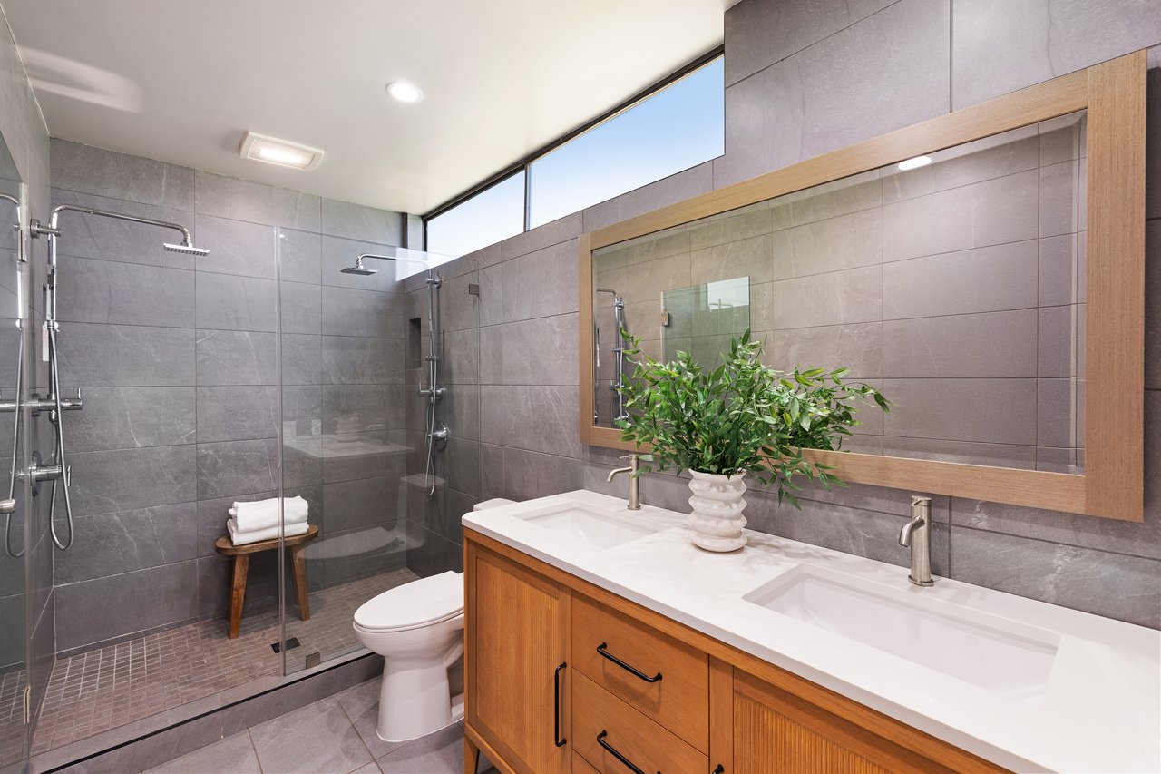 Contemporary bathroom with a glass-enclosed shower and double-sink wood vanity.