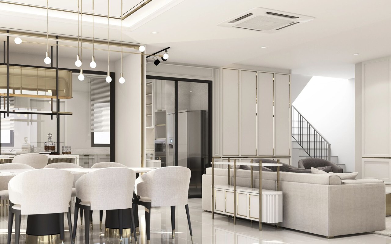 Open-plan living and dining room with a pale sectional sofa, white chairs, and modern pendant lights.