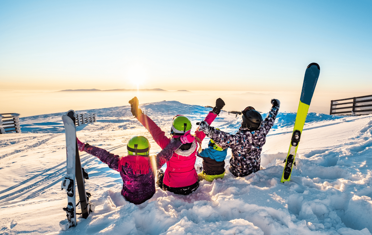 A family celebrates at the top of a mountain during ski season in Colorado