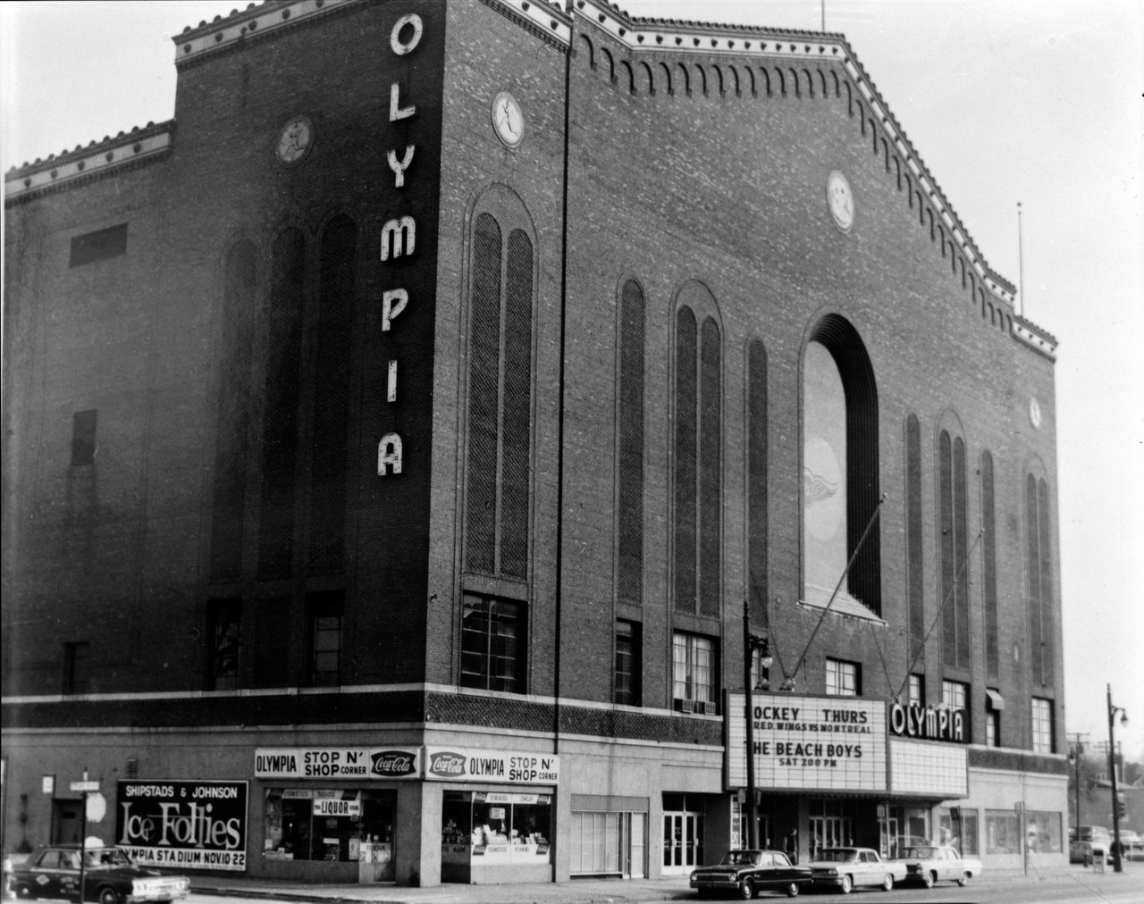 Olympia Stadium’s brick exterior with its vertical sign and marquee advertising hockey and the Beach Boys.