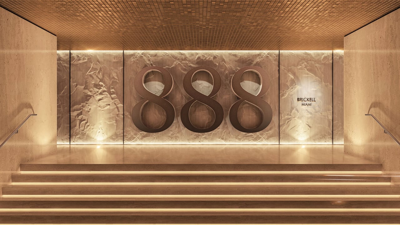 888 Brickell Miami lobby with illuminated stone feature wall and broad steps.