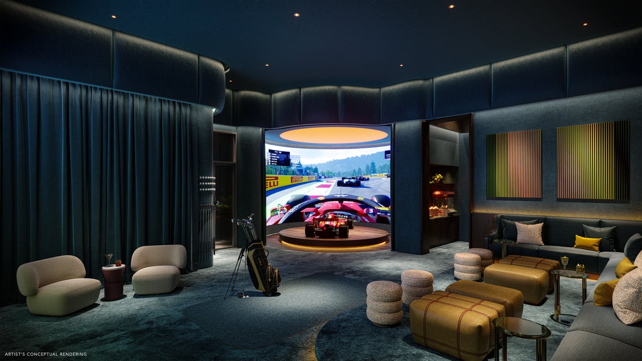 Entertainment lounge with a large racing simulator screen, upholstered seating, and ottomans.