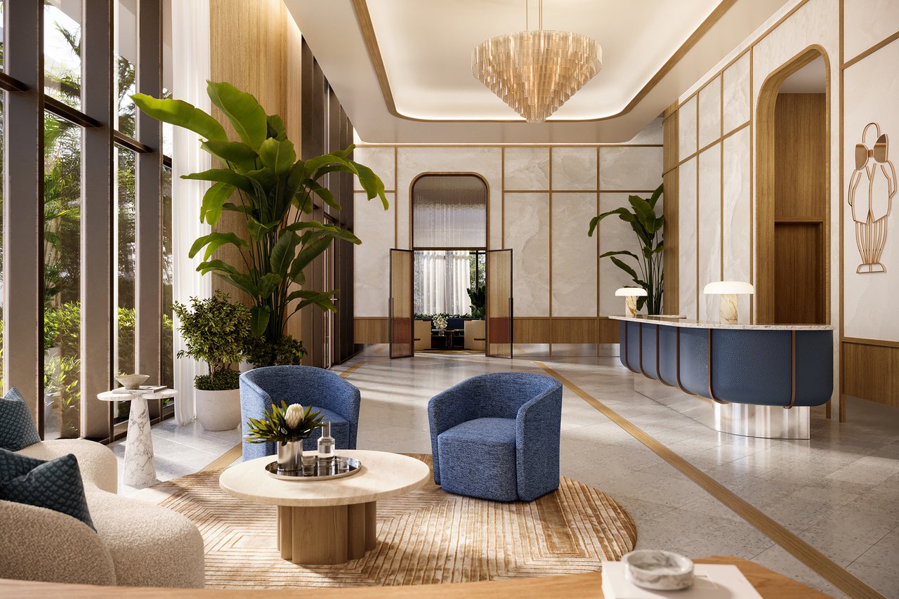 Mr. C Residences lobby with a curved blue reception desk and tall windows.