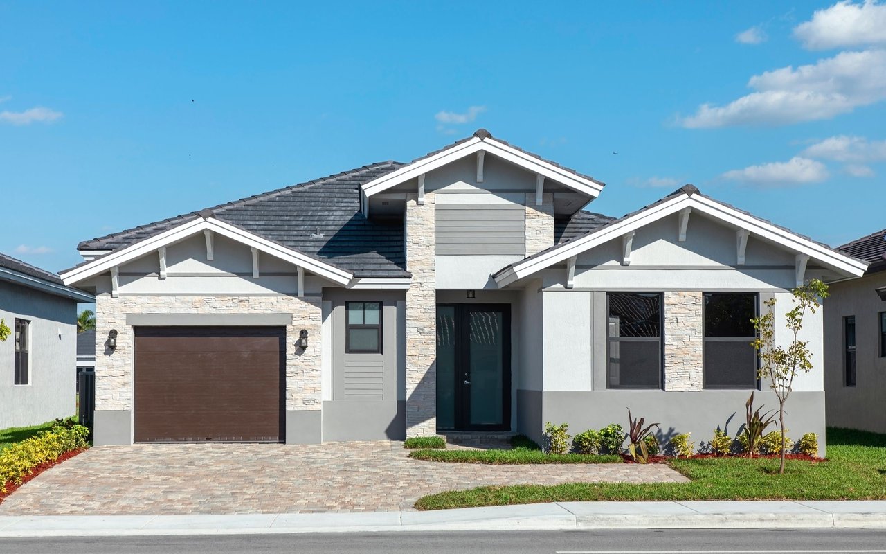 Single-story home with stone accents, a brown garage door, and a paved driveway.