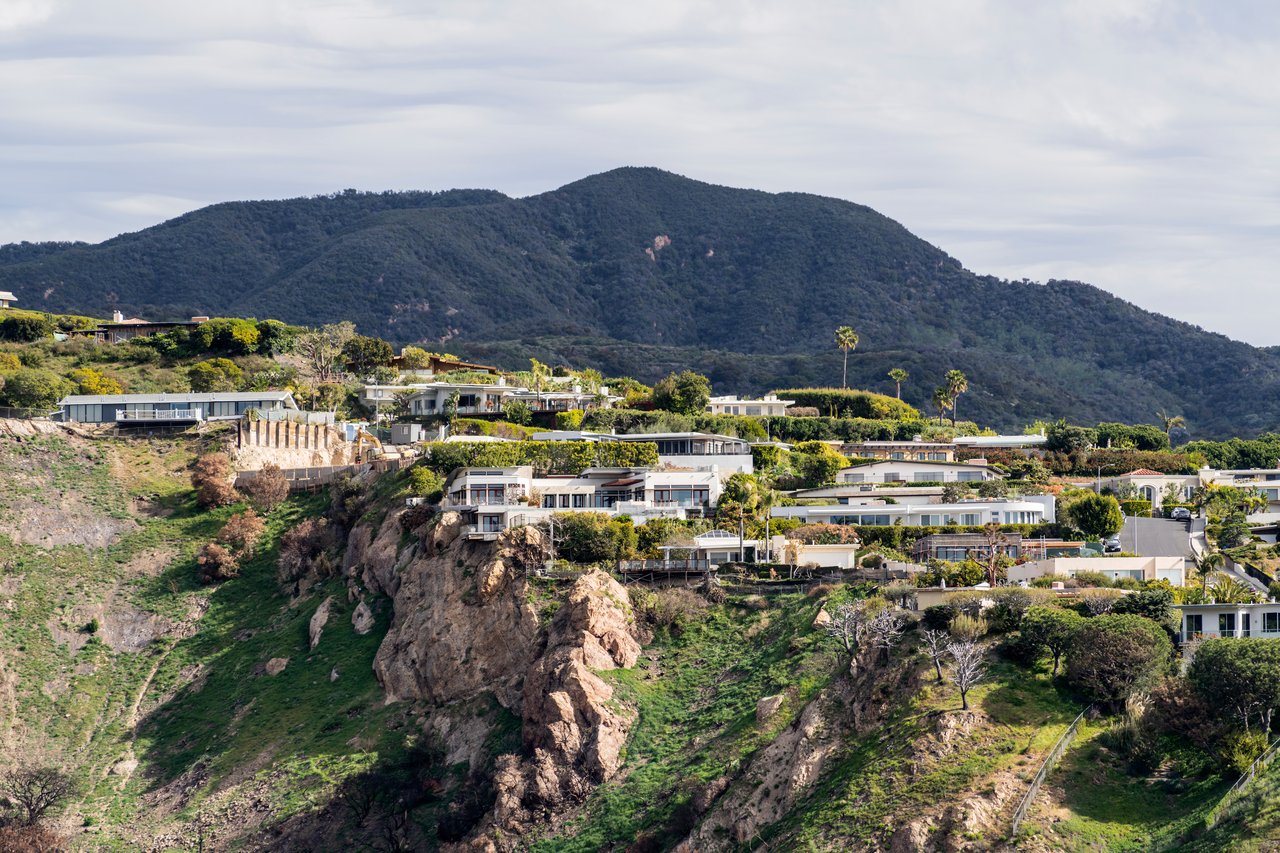 Mount Washington hillside homes beneath a rugged, densely vegetated mountain.