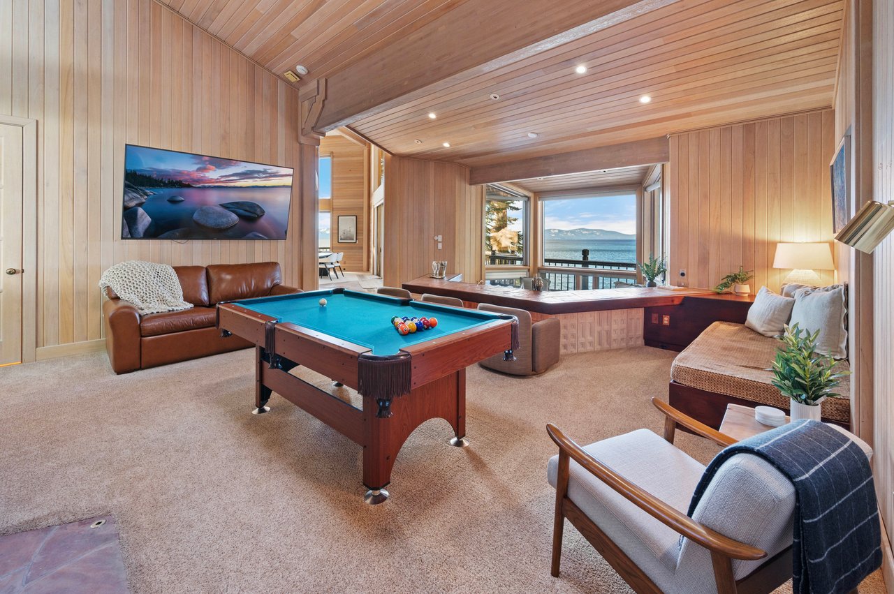 Game room with a pool table and lake and mountain views through broad windows.