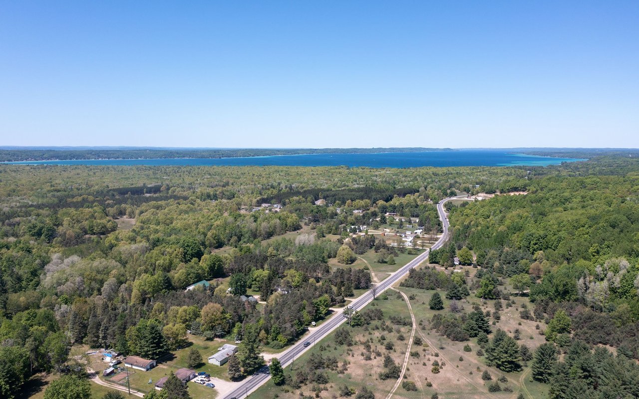 Aerial view of Bingham Township, with a winding road, wooded land, and a blue lake in the distance.