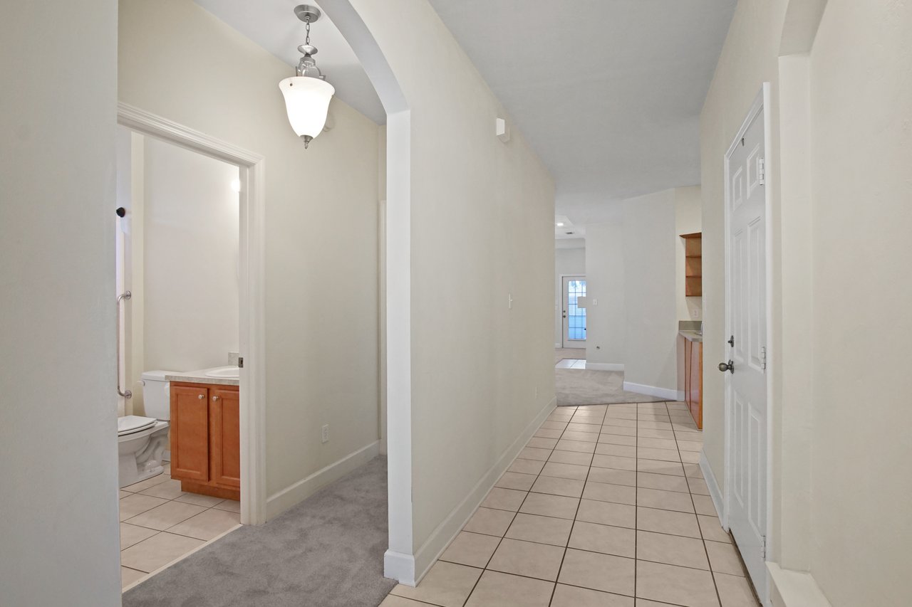 Hallway at 5441 Hampton Hill Circle, Tallahassee, Florida 32311 with arched entry, tile flooring, and view toward living area.