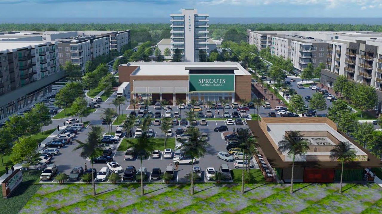 Aerial rendering of an apartment community with a central Sprouts Farmers Market and a tower marked SKYWAY.