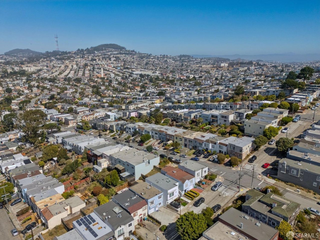 Aerial view of San Francisco homes, with dense streets in the foreground and houses covering distant hills.