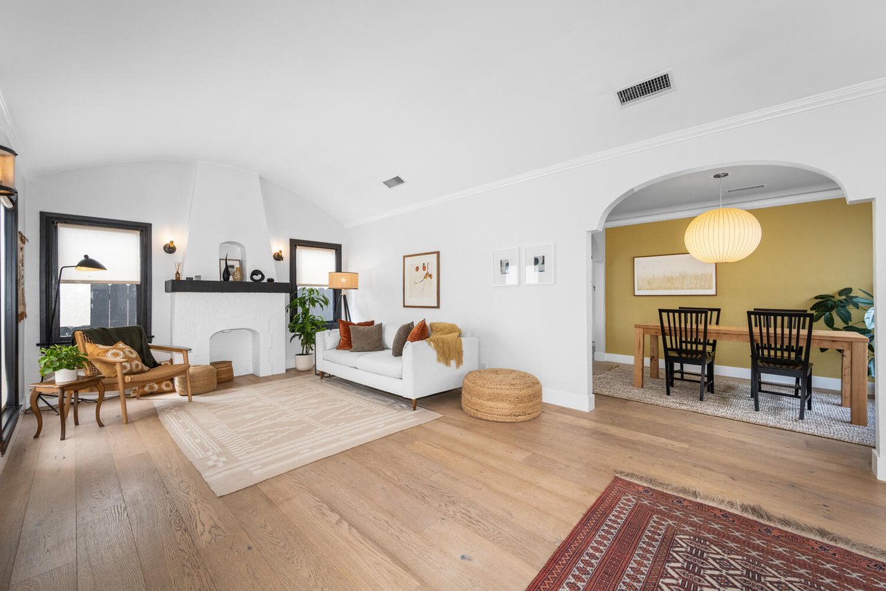 Belmont Shore bungalow living room with open layout, wood floors, fireplace and dining area in Long Beach California