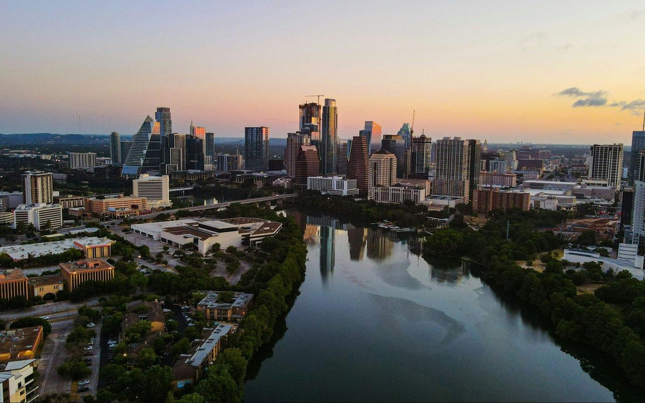 Austin skyline at golden hour, reflected in Lady Bird Lake.