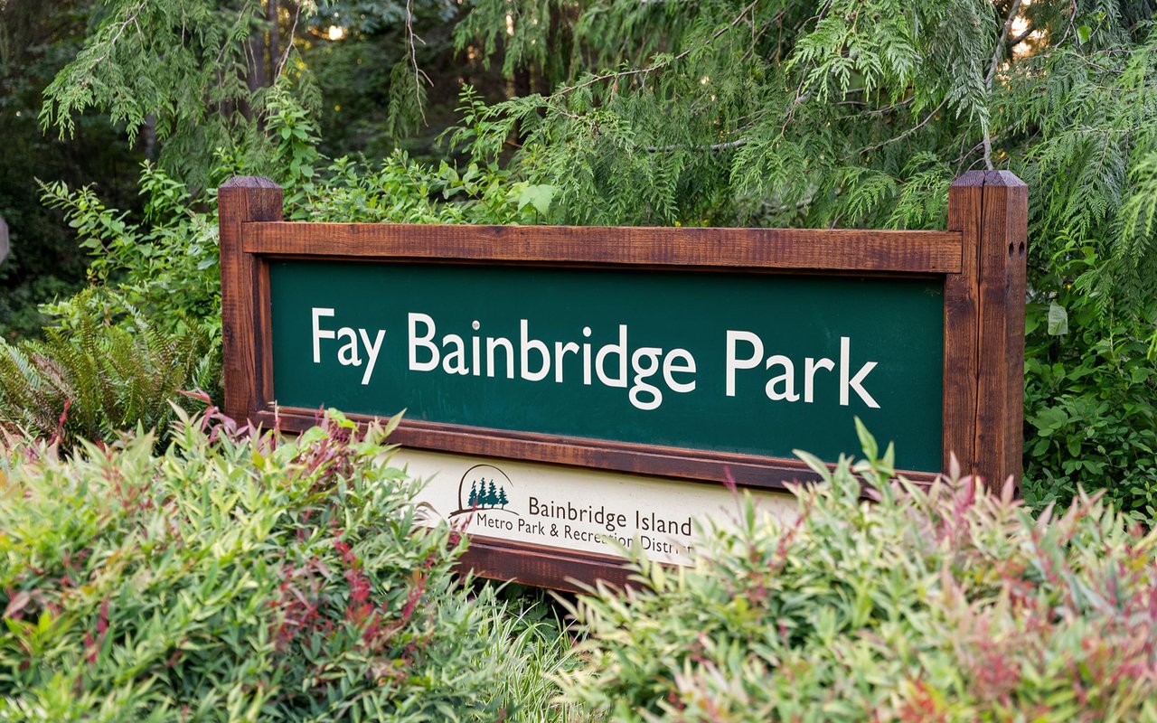 Fay Bainbridge Park sign amid dense greenery.