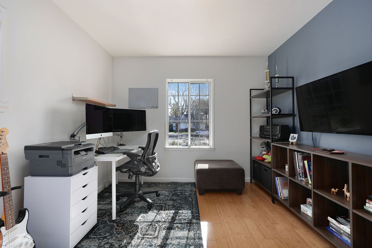 Productive office space with dual-monitor setup, storage wall, and stylish shelving at 17049 Baltar St