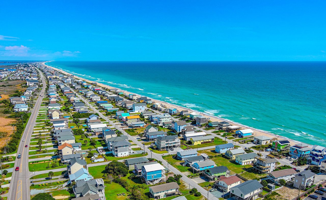 Aerial view of Topsail Beach homes along the sandy shore and turquoise Atlantic Ocean.