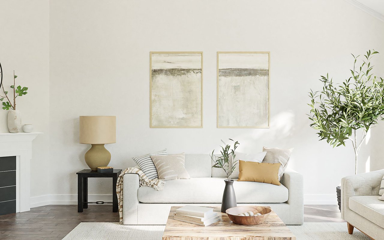 Staged living room with a white sofa, pale wood coffee table, fireplace, and leafy plants.