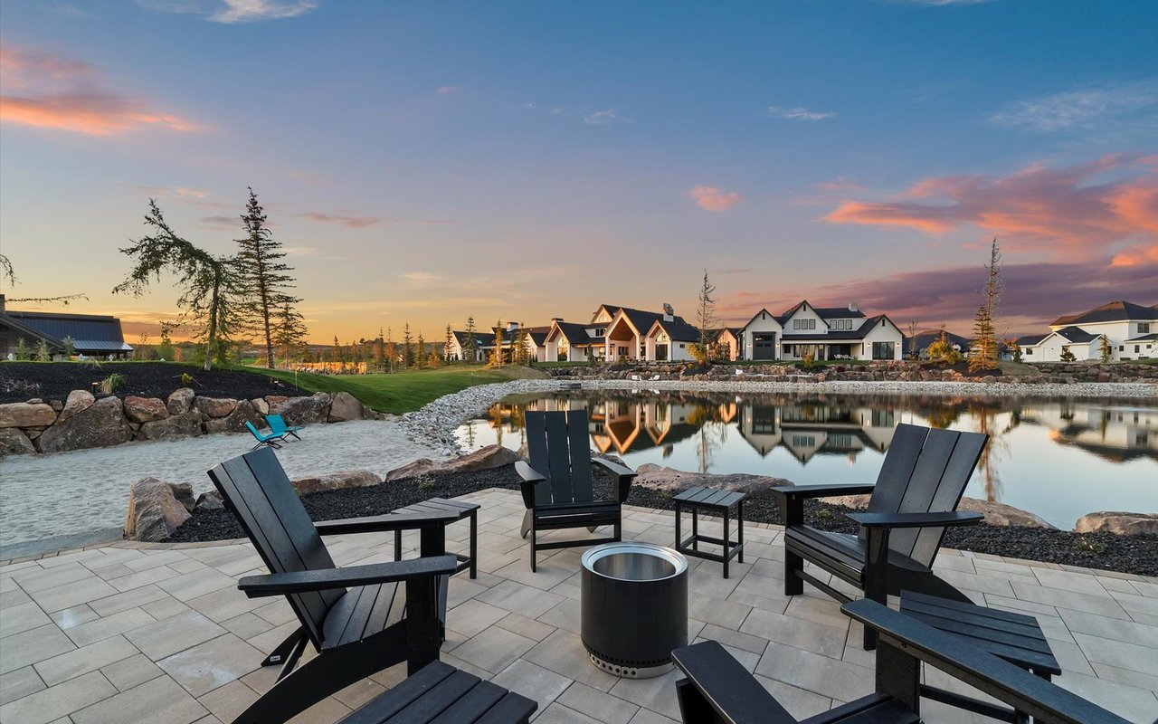 Lakeside patio, looking northwest across the lake - pavers, sandy beach, lake and black wood patio furniture